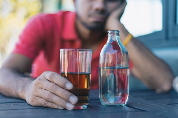 Alcohol addicted man sleeping at the table , Hangover depressed man after hard drinking.