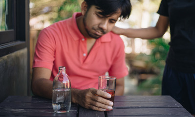 Alcohol addicted man sleeping at the table , Hangover depressed man after hard drinking.