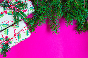 Christmas and New Year theme decorated background, top view, with Christmas tree branches, ornaments and wrapped up gifts in craft paper