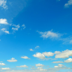White clouds in the blue sky .