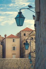 Vintage living buildings with lanterns along the stone wall in old european city