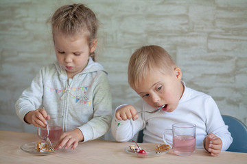 A boy with Down syndrome and a beautiful girl have lunch together. Inclusive society. Psychiatric...