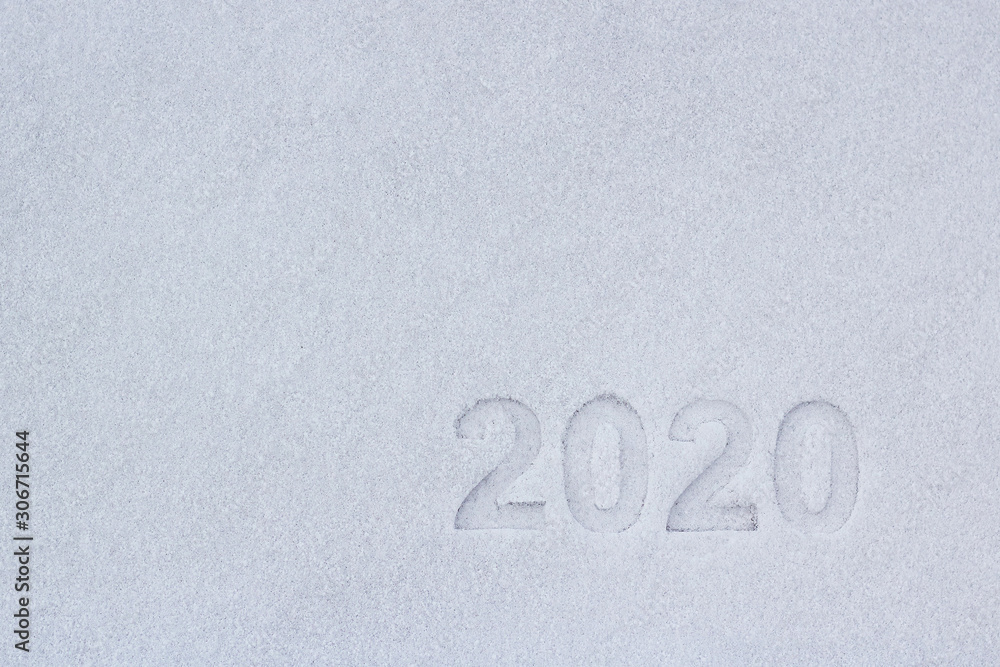 Fototapete the text of the numbers two thousand twenty in the snow, as a symbol of the coming new year.