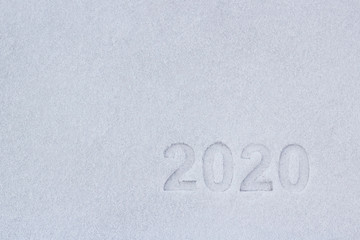 the text of the numbers two thousand twenty in the snow, as a symbol of the coming new year.