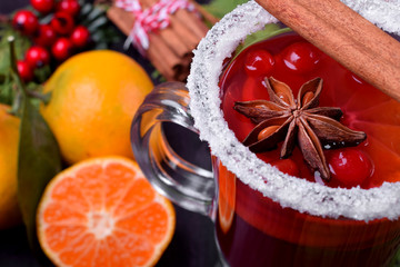 Hot mulled wine with slices of citrus fruits, cinnamon and anise in an Irish glass decorated with...
