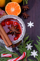 Hot mulled wine with slices of citrus fruits, cinnamon and anise in an Irish glass decorated with sugar border