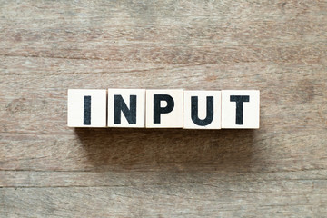 Letter block in word input on wood background