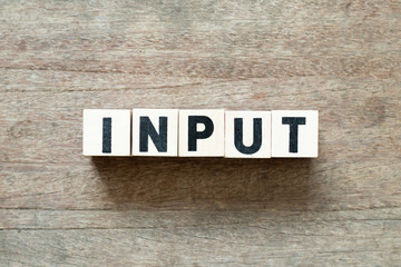 Naklejka premium Letter block in word input on wood background