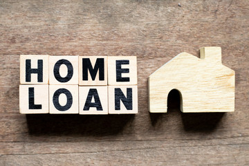 Letter block with word home loan and home model on wood background