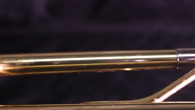 Panning shot of the mouthpiece and three valves of a brass trumpet. A musical instrument