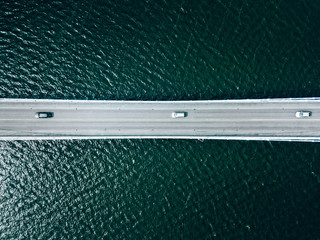 Aerial view of bridge road with cars over lake or sea in Finland