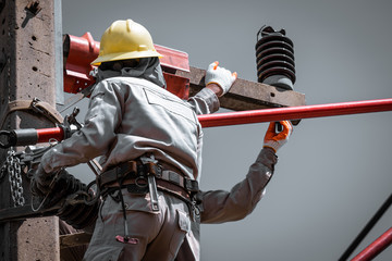 The lineman are replacing damaged insulator insulators by using insulated wire-tong sets, tie stick...