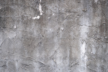 Gray concrete wall texture painted with white. The old white color that has been fading and peeling off. Texture of old dirty concrete wall for background.
