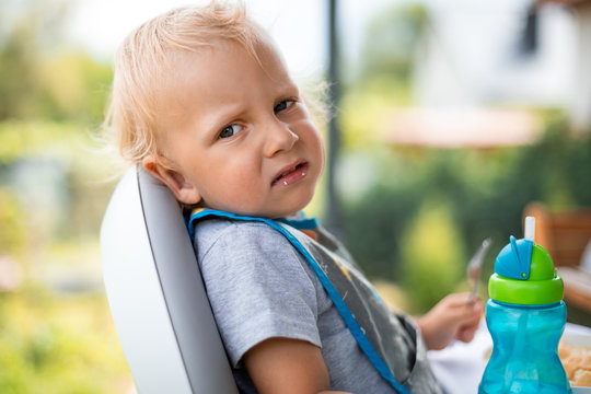 Offended And Fussy Little Child Boy During Eating Outdoor