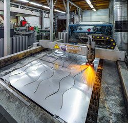 Plasma cutting of metal. View of working machine with sheet of metal. Metalworking.