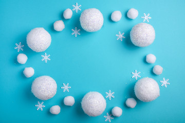 Fototapeta na wymiar Christmas, winter frame of white balls and snow. Snowy Christmas pattern on a light blue background Winter holiday