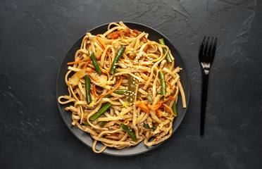 Asian vegetarian food udon noodles with Beijing cabbage, carrots, green beans, bell pepper, onions...