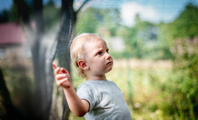 Portrait of sad little child after finishing play on trampoline
