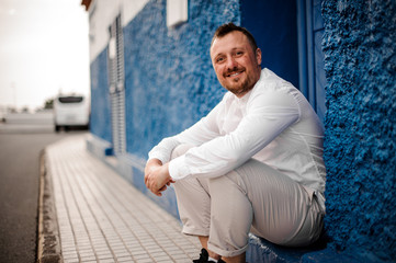 Man sitting on threshold in white outfit