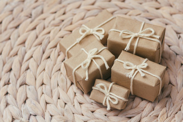 Set of parcels wrapping in brown craft paper and tie hemp string. Package. Delivery service. Online shopping. Your purchase. Gift box on a table. Decorative wood background.