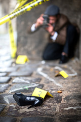 Vintage detective phoPhotographer with vintage camera at the crime scene.