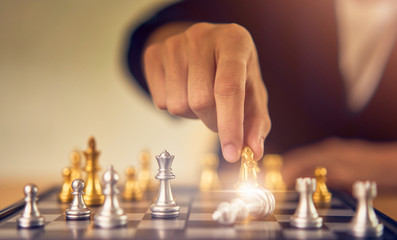 Leadership concept, businessman making the moving chess figure in competition success.