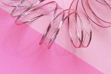 Holiday composition. Beautiful ribbon on a pink background. The shadow of the tape. Holiday, Valentine, Christmas, New Year concept. Top view, flat lay, mock up, mock up, copy space.
