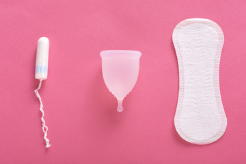 Pad, menstrual cup and tampon isolated over pink background, modern female's hygiene products, choosing best variant for you. Concept of girl's critical days, menstruation cycle, woman's period.