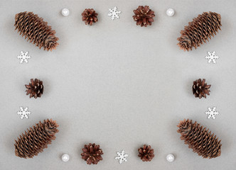 Christmas border with silver snowflakes and fir cones on a gray background. Happy New Year. Winter concept. Space for text.