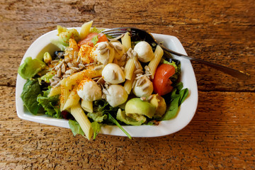 vegetarian mozzarella salad in a bowl on wooden table