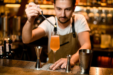 Bartender puts piece of brown sugar in cocktail