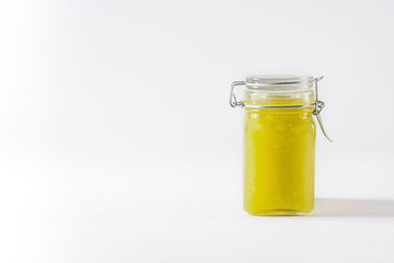 Homemade delicious green jam in glass jar on white background. Copy space.