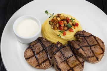 Prepared beef tongue with mashed potatoes white sauce and vegetables on plate