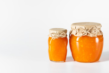 Fototapeta na wymiar Delicious homemade jam in glass jars on a white background.