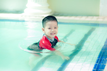 The Asian boy swimming suit has fun at the pool.Portrait of cute little Asian child