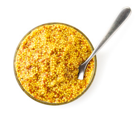 French mustard beans in a plate with a spoon on a white. The view of the top.