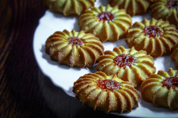 On the table in a white plate lies biscuits sweet sugar with jam