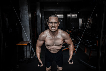 Fototapeta na wymiar Portrait of asian man big muscle at the gym,Thailand people,Workout for good healthy,Body weight training,Fitness at the gym concept,Prank to abdominal muscles,Pull sling