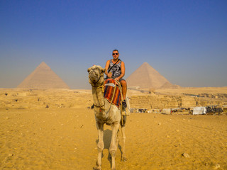 Tourist on camel in front of the Pyramids of Giza. In Cairo, Egypt