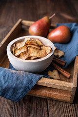 Sweet delicious snack, homemade oven dried crispy pear chips sprinkled with cinnamon