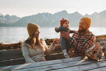 Family parents playing with baby outdoor mother and father with child together vacations healthy lifestyle mountains view in Norway