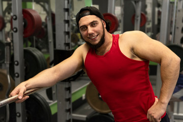 Fototapeta na wymiar Portrait of a strong, muscular guy in the gym. Happy positive athlete smiling.