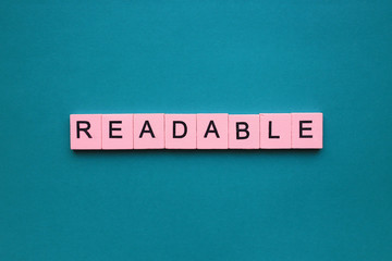 Readable word wooden cubes on the green background.