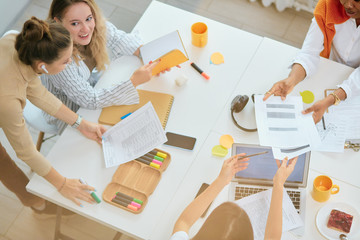 Business co-working of female, women. Beautiful modern ladies sitting in office and discussing new business ideas, share experience