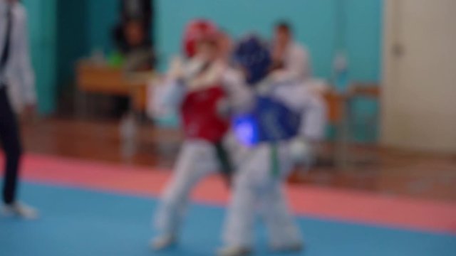Taekwondo sport competitions between youth. Blurry video footage of young boys in sparring.