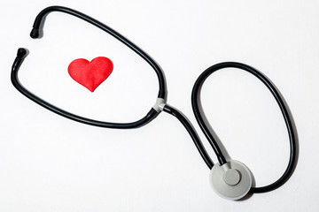 on a white background a red heart inside a stethoscope