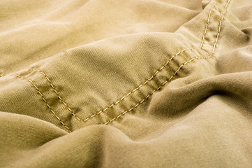 clothing items stonewashed cotton fabric texture with seams, clasps, buttons and rivets, macro