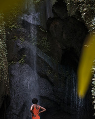 chica afro posando en cascada tropical