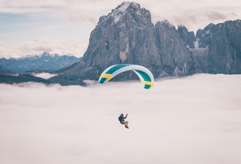 Paragliding over cloud inversion in Dolomites Italy