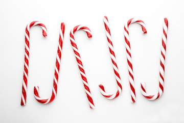 Christmas candy canes on white background. Minimal composition with peppermint candies. Top view